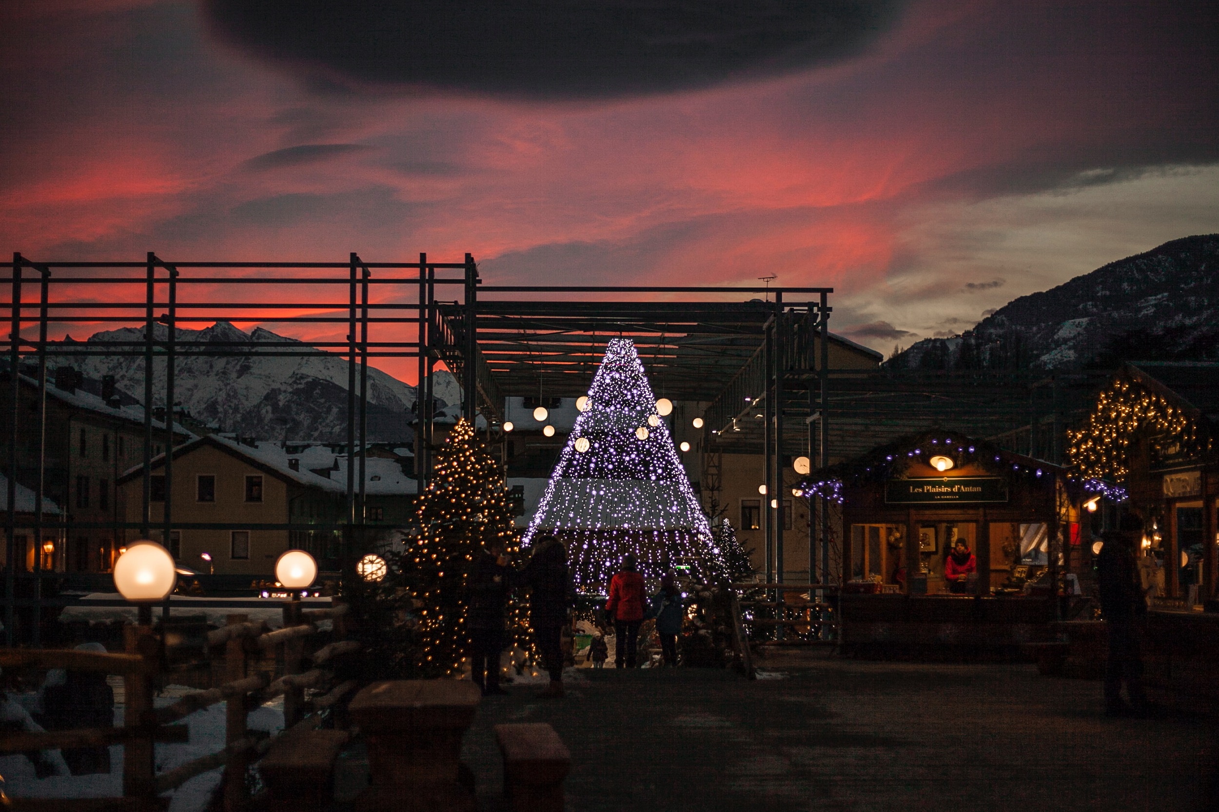 Christmas market with the sun setting and snowy mountains