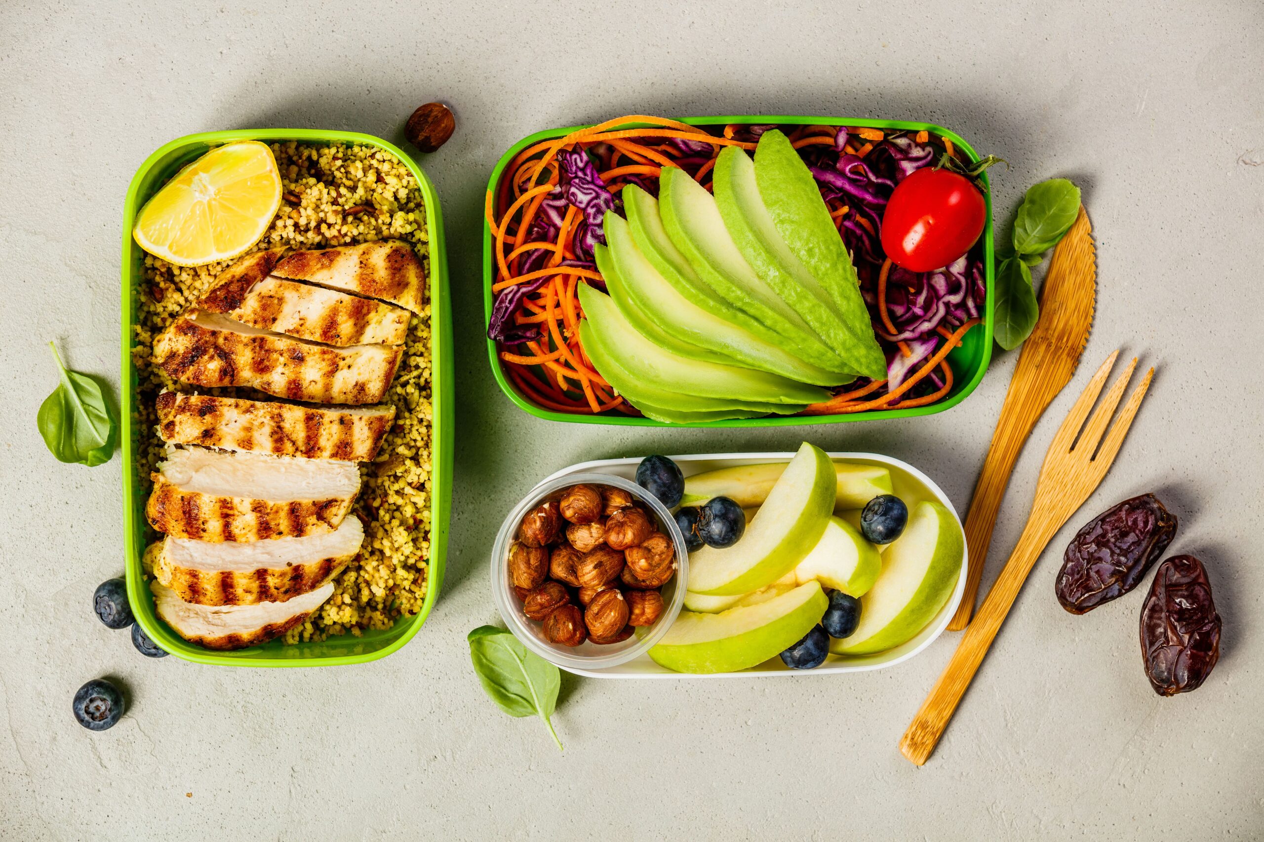 Healthy prepared meal of chicken, salad, and fruit