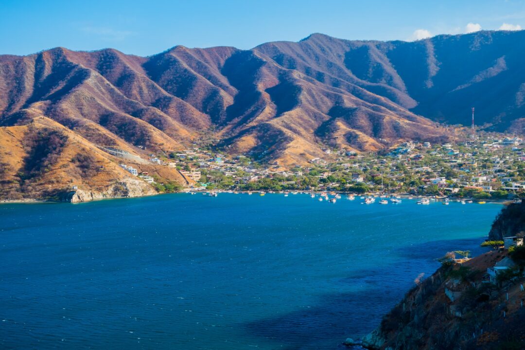 Photo of an ocean coast with a town and mountains