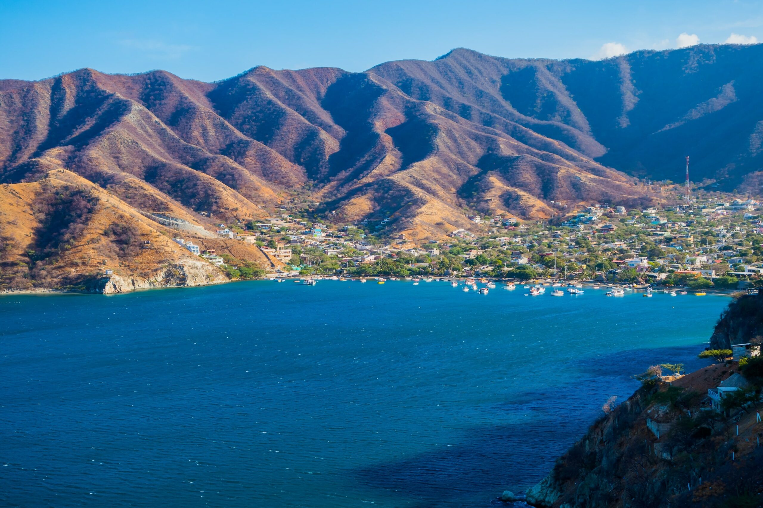 Photo of an ocean coast with a town and mountains