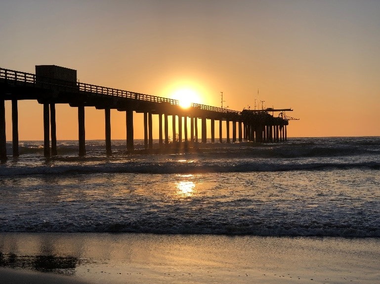 Pier on the beach at sunset